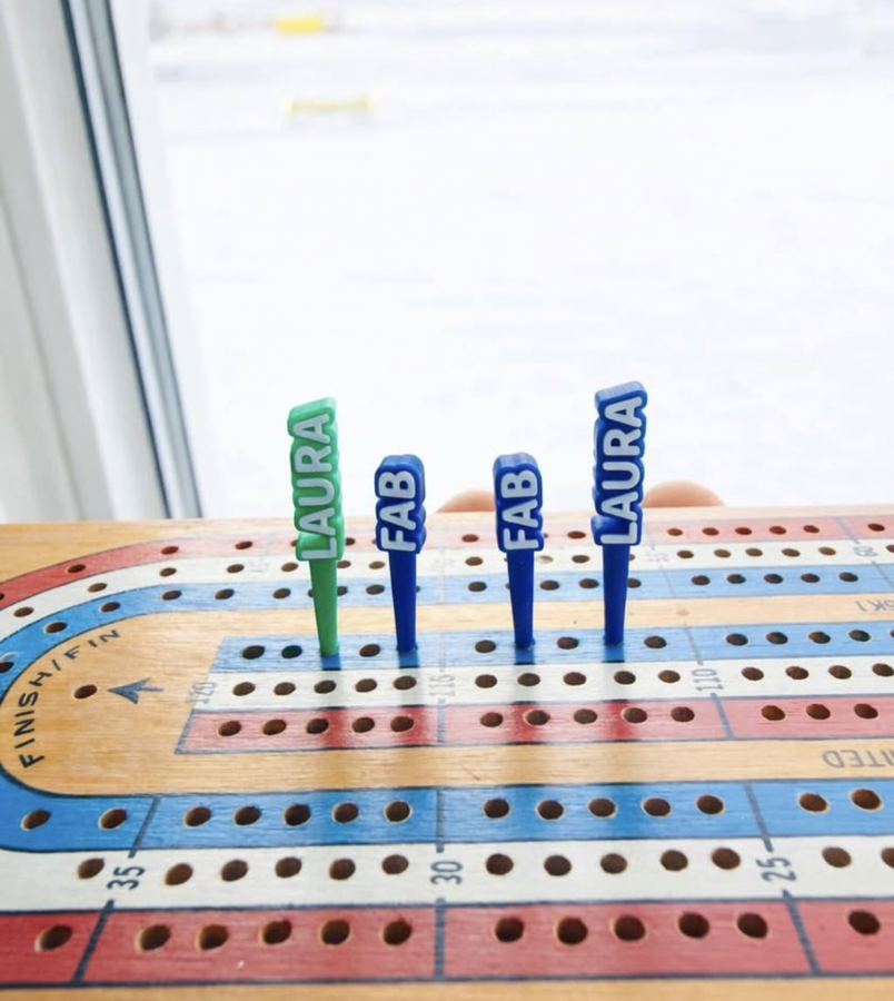 Custom cribbage pegs printed with names, standing in a standard 1/8 inch cribbage board